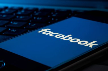 Cagliari, Sardinya, İtalya - 30 10 2021 - Bir bilgisayar klavyesinde cep telefonu akıllı telefon Facebook sosyal ağ uygulama logosu başlangıç ekranında