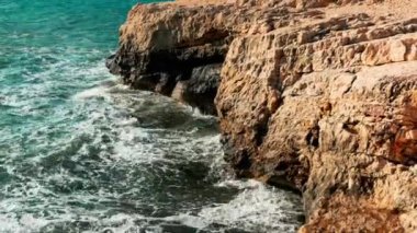 Deniz dalgaları kayalıklara çarpar, Akdeniz turkuaz suyu yaz günü