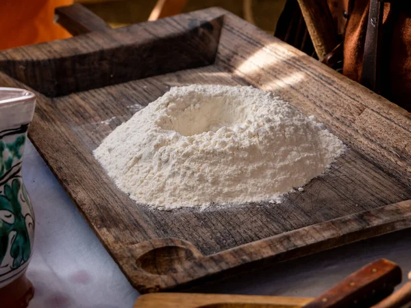 Hamur için un hazırlamak için masaya ahşap tepsi koyun.