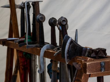 Ortaçağ silahlarının, kılıçların ve baltaların ahşap bir rafta yeniden canlandırılması.