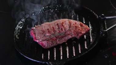 İndüksiyon tabağında biftek buharı pişiyor.