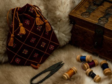 medieval reenactment objects, sewing set with spools of wool scissors and a cloth bag on a fur