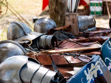 Ortaçağ canlandırması - miğferler, plaka zırh parçaları, kemerler ve diğer deri eşyalar gibi orta çağ asker teçhizatlarıyla dolu bir masa