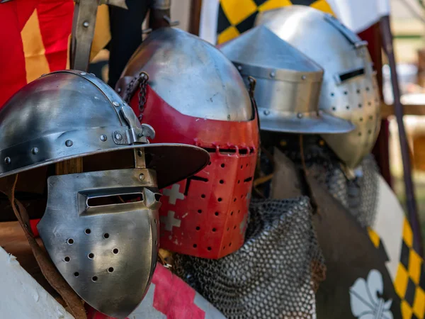 stock image medieval historical reenactment - display of various types of medieval plate armor helmets or lighter metal helmets