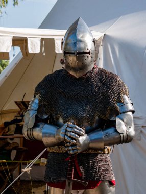 Ortaçağ canlandırması. Kameranın önünde poz vermiş orta çağ zırhı giymiş yetişkin bir adam.