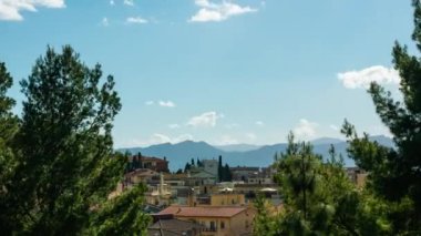 time lapse small Italian town surrounded by nature between trees and green hills