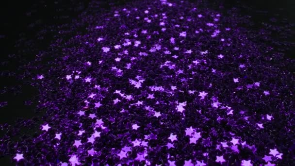 Dispersion d'étoiles violettes scintillantes scintillent sur un fond noir Vidéo De Stock Libre De Droits