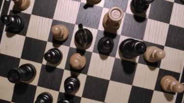 Beyaz ve siyah tahta satranç figürleriyle dönen satranç tahtası üst görünüm