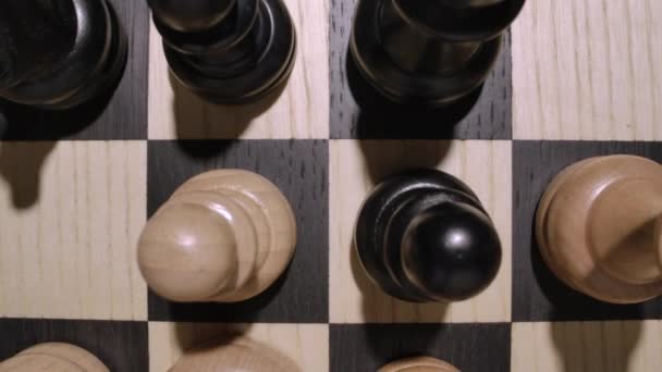 Sakktábla fehér és fekete fából készült sakkfigurákkal a makrótól a tetejéig. — Stock videók