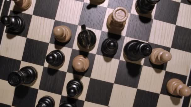 Forgó sakktábla fehér és fekete fából készült sakkfigurákkal felülnézet — Stock videók