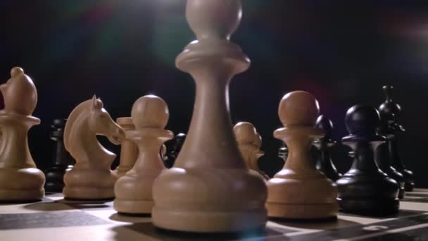 Rotierendes Schachbrett mit einer Kombination aus weißen und schwarzen Holzfiguren — Stockvideo