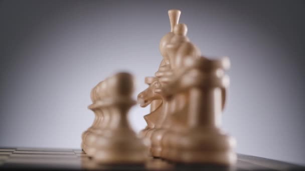 Échiquier rotatif avec des lignes de figures d'échecs en bois blanc Vidéo De Stock