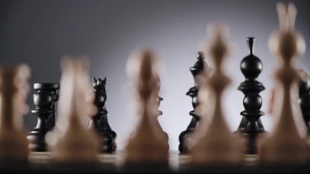Schaakbord met lijnen van witte en zwarte houten schaakfiguren — Stockvideo