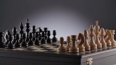 Beyaz ve siyah satranç figürleriyle dönen satranç tahtası