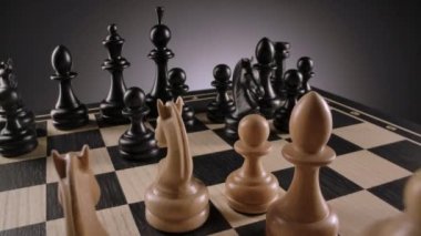 Beyaz ve siyah satranç figürleriyle dönen satranç tahtası