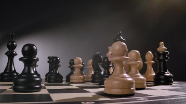 Tablero de ajedrez giratorio con combinación de figuras de ajedrez de madera blanca y negra — Vídeo de stock