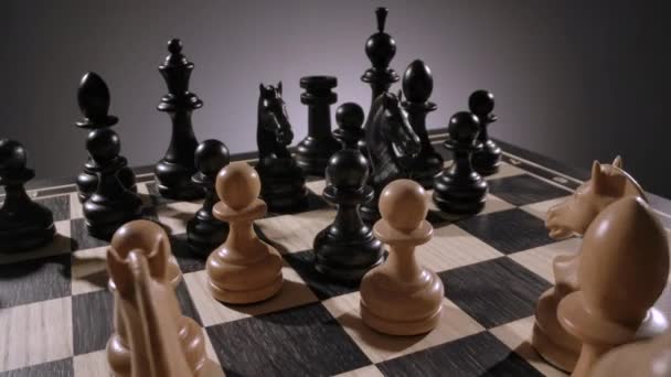 Rotierendes Schachbrett mit einer Kombination aus weißen und schwarzen Holzfiguren — Stockvideo