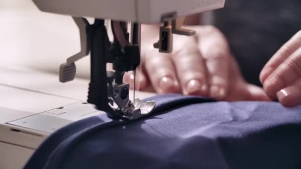 Kvinnor händer syr ett blått tyg på symaskin — Stockvideo