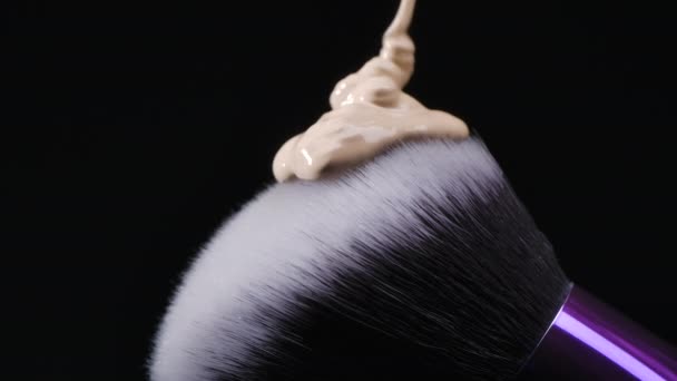 La base beige se derrama sobre un cepillo de maquillaje — Vídeo de stock