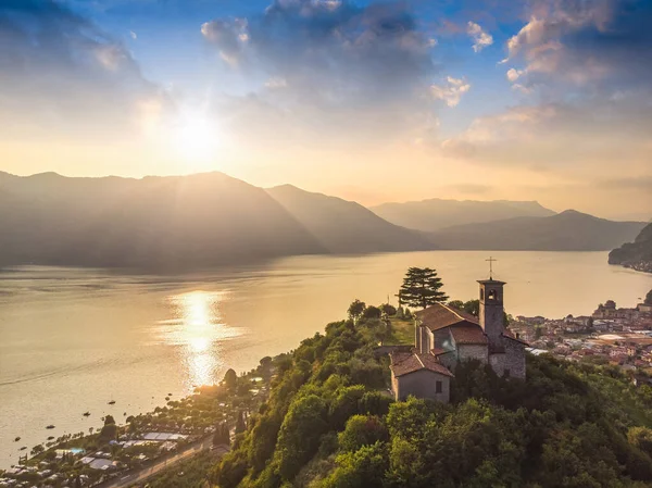Hermosa vista panorámica aérea desde el dron hasta el lago Iseo con iglesia en la cima de la colina, Lombardía, Italia — Foto de Stock