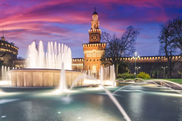 Castillo de Sforza con una fuente en la noche. Hermosa iluminación del edificio en colores cálidos. Milán Italia — Foto de Stock