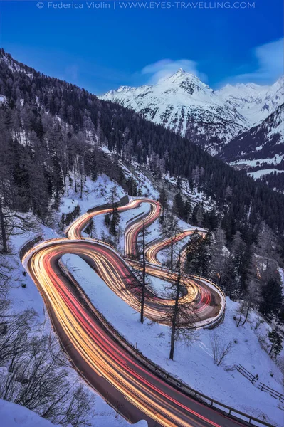 Larga exposición con senderos ligeros de la carretera Maloja Pass en Engadin durante la hora azul en invierno, Suiza — Foto de Stock