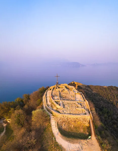 Повітряний вид фортеці з хрестом на пагорбі на фоновому озері Гарда. Panorama on the rocca di manerba top view. — стокове фото
