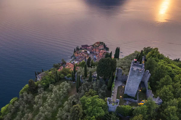 Aerial view of Vezio Castle and Varenna village in background during summer sunset. Drone shot in Como lake. Varenna, Italy — Foto de Stock