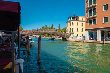 VENICE, İtalya - 27 Ağustos 2021: Venedik 'teki kanalların köprüsünün altından geçen tekne görüntüsü.