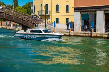 VENICE, İtalya - 27 Ağustos 2021: Polis botu tipik bir Venedik su kanalı üzerinde yol alıyor.