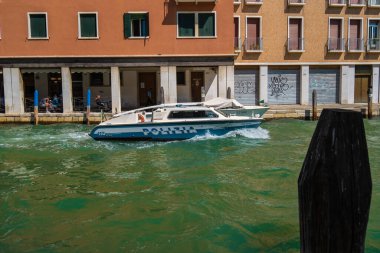 VENICE, İtalya - 27 Ağustos 2021: Polis botu tipik bir Venedik su kanalı üzerinde yol alıyor.