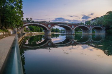 İtalya 'nın Torino kentindeki Po nehri üzerindeki kemer köprüsünün güzel günbatımı manzarası.