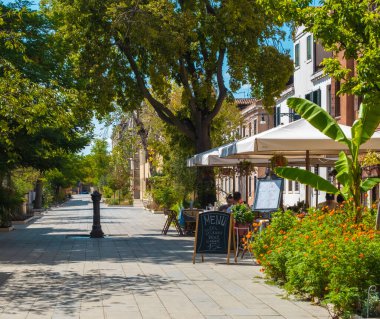 VENICE, İtalya - 27 Ağustos 2021: Venedik sokaklarındaki tipik bir İtalyan restoranında yemek yiyen ailelerin görüntüsü.