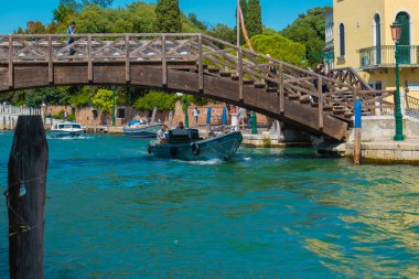 VENICE, İtalya - 27 Ağustos 2021: Venedik 'teki kanalların köprüsünün altından geçen tekne görüntüsü.