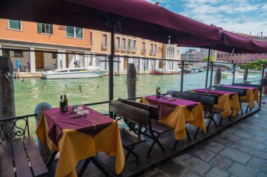VENICE, ITALY - August 27, 2021: View of empty restaurant tables due to the pandemic on the canals of Venice.