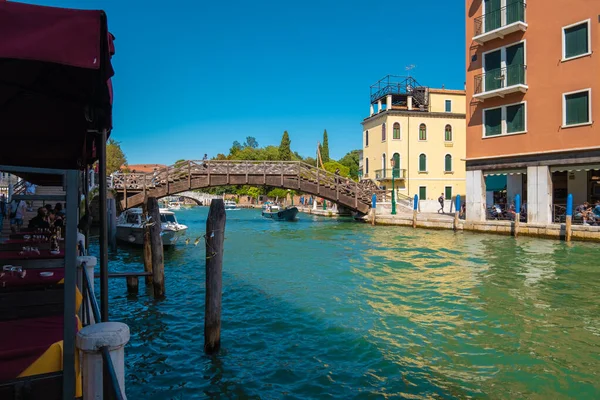 VENICE, İtalya - 27 Ağustos 2021: Venedik 'teki kanalların köprüsünün altından geçen tekne görüntüsü.