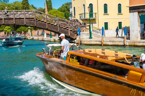 VENICE, İtalya - 27 Ağustos 2021: Tipik bir Venedik su kanalı üzerinde seyreden taksi teknesinin kapanışı.