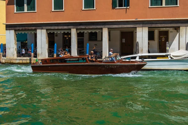 VENICE, İtalya - 27 Ağustos 2021: Venedik kanallarında turistleri taşıyan taksi teknesinin görüntüsü.