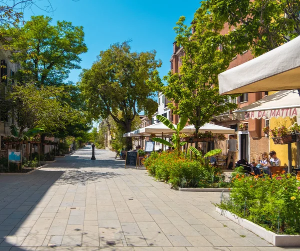 VENICE, İtalya - 27 Ağustos 2021: Venedik sokaklarındaki tipik bir İtalyan restoranında yemek yiyen ailelerin görüntüsü.