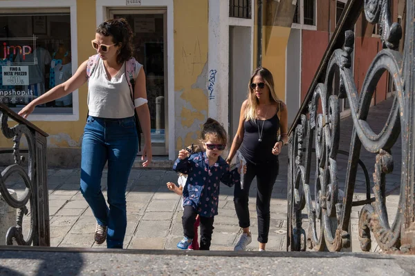 VENICE, İtalya - 27 Ağustos 2021: Venedik kanallarının köprülerinde yürüyen bir grup anne ve kız.