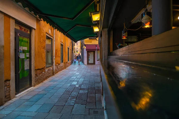 VENICE, İtalya - 27 Ağustos 2021: Venedik 'in merkezindeki dar tarihi ara sokak ve bitişiğindeki bar manzarası.