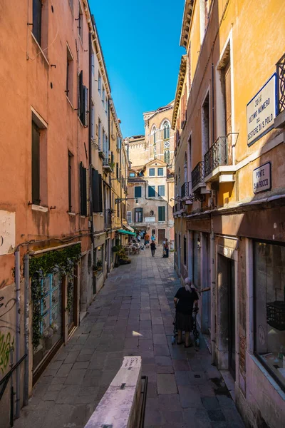 VENICE, İtalya - 27 Ağustos 2021 Venedik 'te dar bir sokakta tarihi evlerde gezen insanların görüntüsü.
