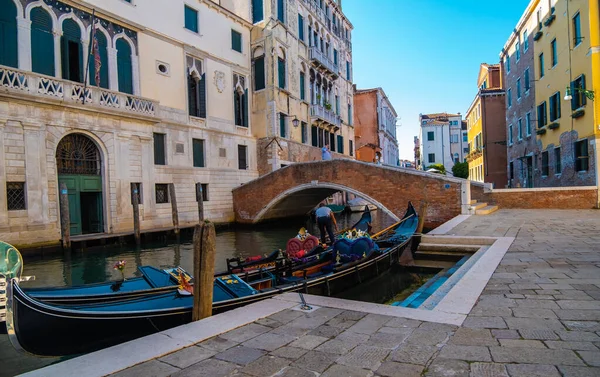 VENICE, İTALYA - 27 Ağustos 2021: Boş kanallarda müşterileri bekleyen gondolcuların ve salgında Venedik 'in görüntüsü.