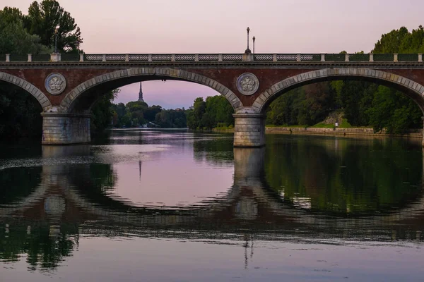 İtalya 'nın Torino kentindeki Po nehri üzerindeki kemer köprüsünün güzel günbatımı manzarası.