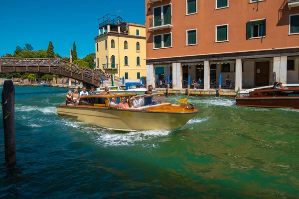 VENICE, İtalya - 27 Ağustos 2021: Venedik kanallarında turistleri taşıyan taksi teknesinin görüntüsü.