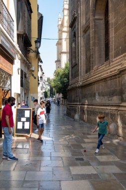 GRANADA, SPAIN - SEPTEMBER 25, 2021: View of people strolling through the historic center of Granada near the Cathedral