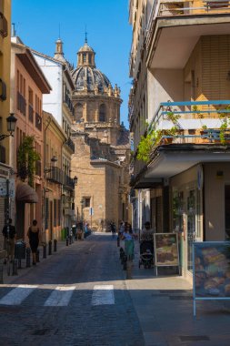 GRANADA, SPAIN - SEPTEMBER 25, 2021: View of tourists on streets of Granada with a church on background.