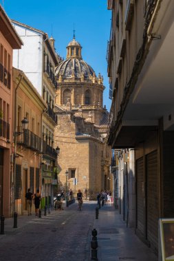 GRANADA, SPAIN - SEPTEMBER 25, 2021: View of tourists on streets of Granada with a church on background.