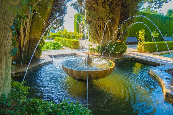 View of beautiful fountain from Alhambra gardens in Granada.