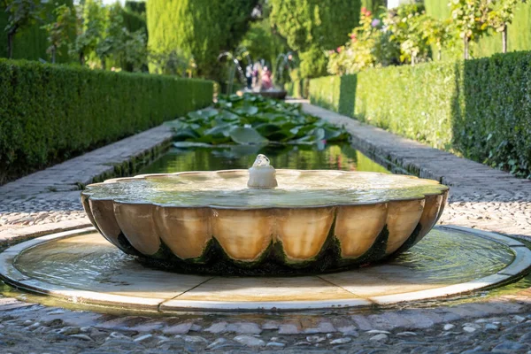 View of beautiful fountain from Alhambra gardens in Granada.